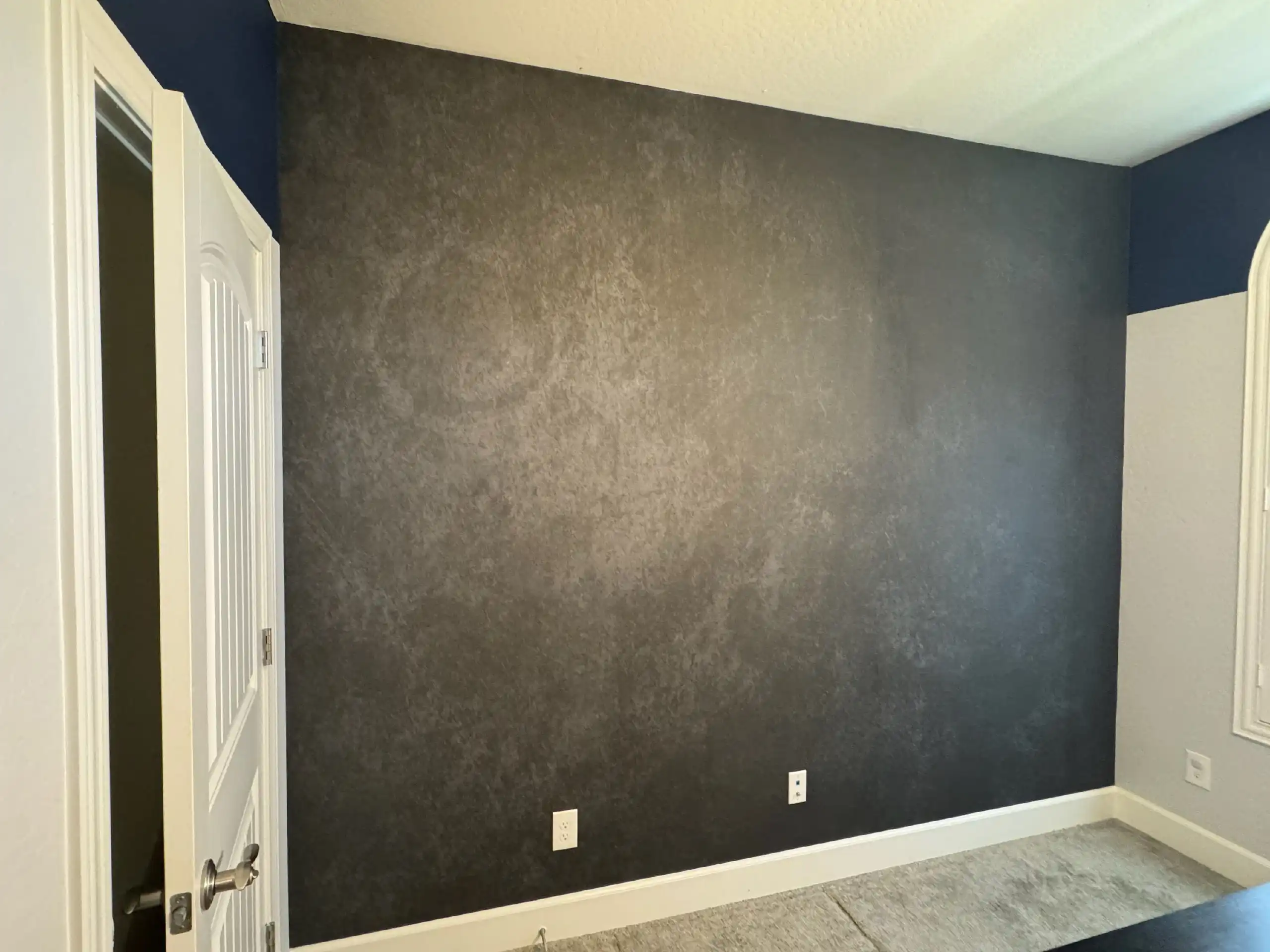 Textured charcoal wallpaper on a finished interior wall